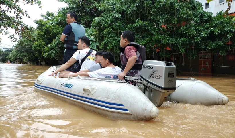 Lực lượng cứu hộ đưa người dân ra khỏi khu vực ngập lụt. Ảnh: Tuấn Anh/TTXVN()