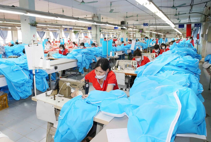 Công ty cổ phần May Chiến Thắng chuyển đổi dây chuyền sang may quần áo bảo hộ y tế. (Ảnh: Phương Hoa/TTXVN)
