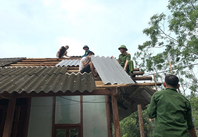 Lực lượng tại chỗ giúp các hộ gia đình lợp lại mái nhà. (Ảnh: TTXVN phát)