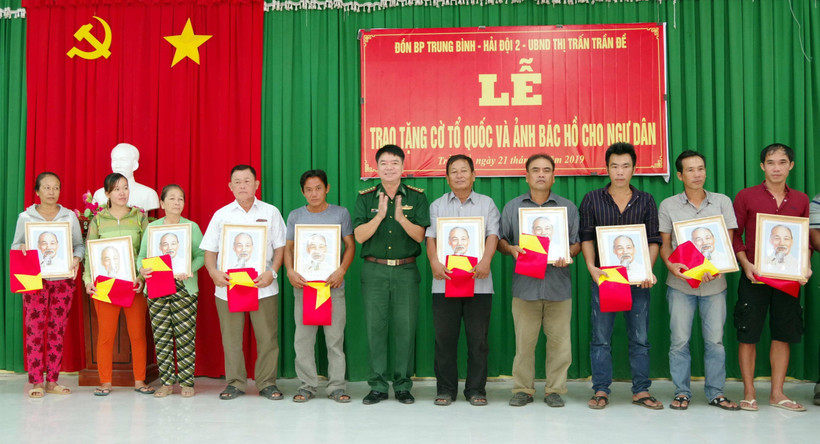 Lãnh đạo bộ đội biên phòng Sóc Trăng trao tặng cờ và ảnh bác Hồ cho ngư dân vùng ven biển Sóc Trăng. (Ảnh: Trung Hiếu-TTXVN)