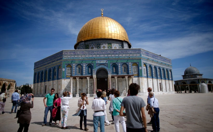 Khách du lịch chụp ảnh bên ngoài Thánh đường Hồi giáo tại thành cổ Jerusalem. (Ảnh: AFP/TTXVN)