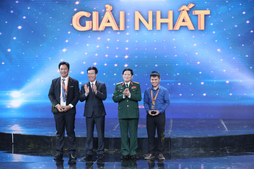 Ông Võ Văn Thưởng, Uỷ viên Bộ Chính trị, Trưởng Ban Tuyên giáo Trung ương, đồng chí Ngô Xuân Lịch, Ủy viên Bộ Chính trị, Bộ trưởng Bộ Quốc Phòng, trao giải Nhất cho 2 tác giả đoạt giải. (Ảnh: Minh Quyết/TTXVN)
