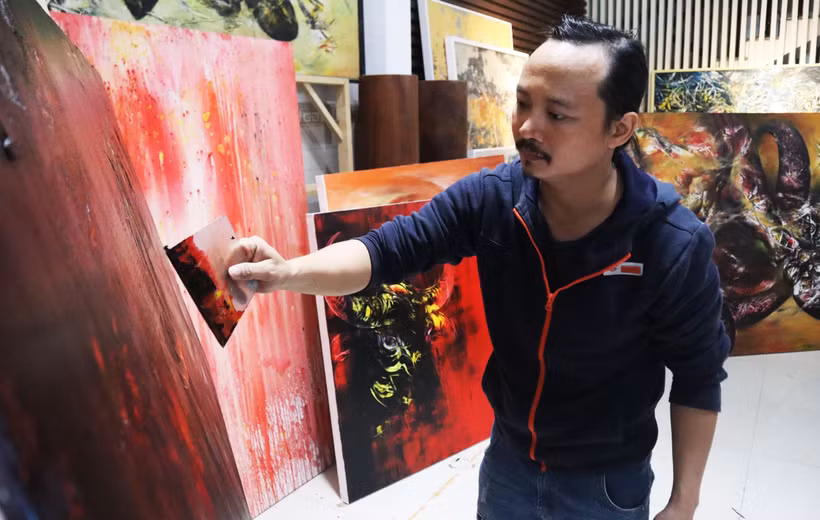 Họa sỹ Ngô Thanh Hùng sáng tác tranh tại nhà. (Ảnh: Văn Dũng/TTXVN)