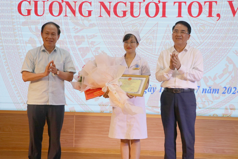 Bí thư Thành ủy Hải Phòng Lê Tiến Châu (trái) và Phó Chủ tịch Ủy ban Nhân dân thành phố Hải Phòng Lê Khắc Nam tặng Bằng khen cho điều dưỡng viên Nguyễn Thị Thảo. (Ảnh: Hoàng Ngọc/TTXVN)