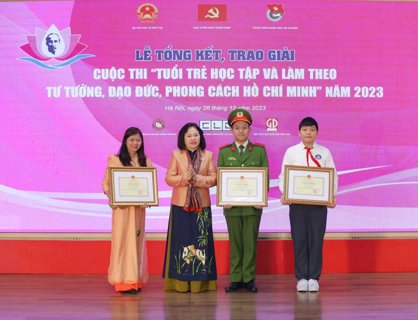 Thứ trưởng Bộ Giáo dục và Đào tạo Ngô Thị Minh trao bằng khen cho các tác giả đạt giải nhất. (Ảnh: Thanh Tùng/TTXVN)