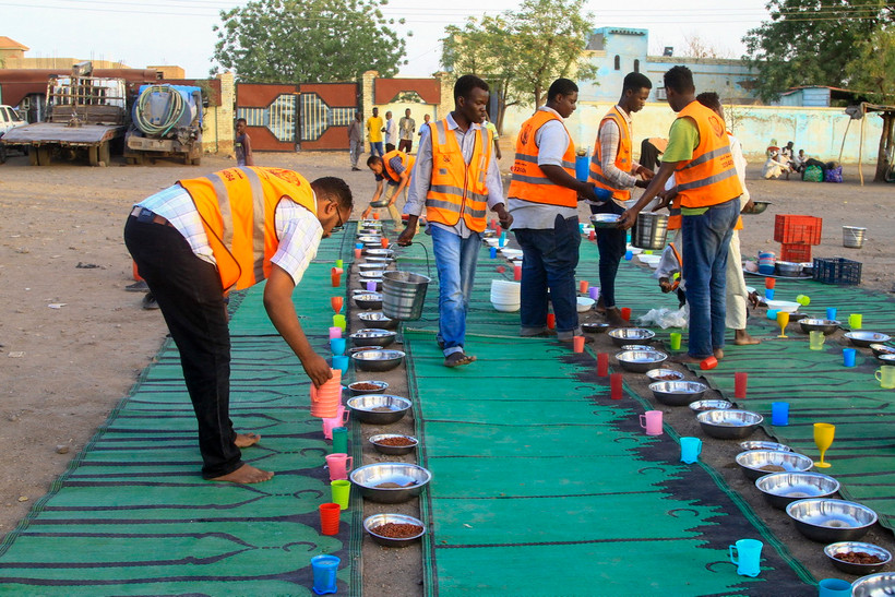 Tình nguyện viên chia suất ăn cứu trợ cho người tị nạn. (Ảnh: AFP/TTXVN)