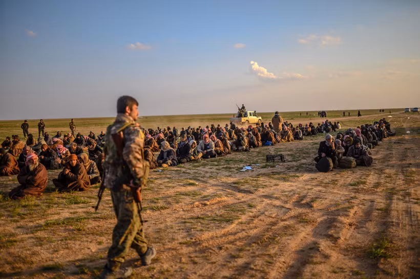 Các tay súng IS đầu hàng Lực lượng Dân chủ Syria được Mỹ hậu thuẫn tại Baghouz, miền Đông Syria ngày 22/2/2019. (Ảnh: AFP/TTXVN)