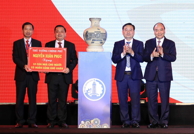 Thủ tướng Nguyễn Xuân Phúc tặng quà lưu niệm và nhà cho người có hoàn cảnh khó khăn huyện Đại Lộc. (Ảnh: Thống Nhất/TTXVN)