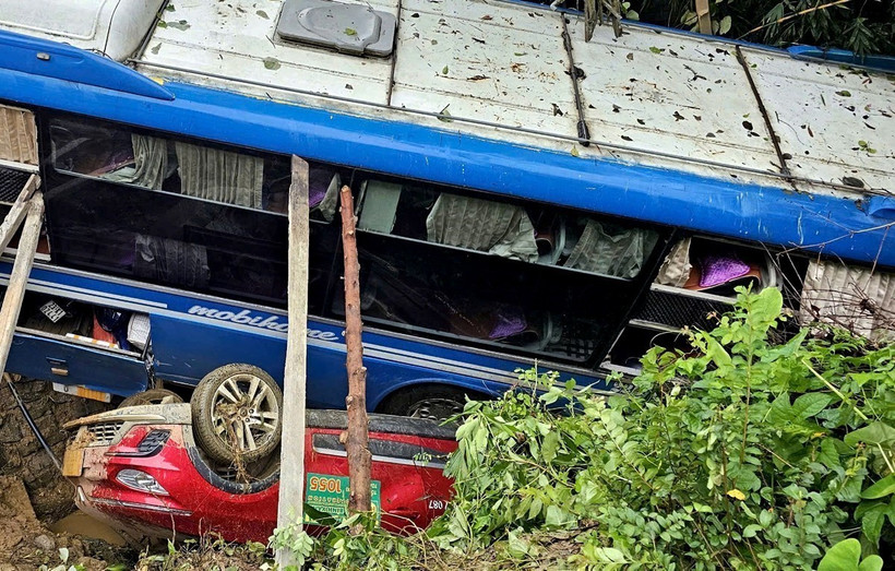 Xe ôtô khách và xe con đang lưu thông thì bất ngờ bị hàng nghìn m3 đất đá sạt lở vùi lấp. (Ảnh: TTXVN phát)