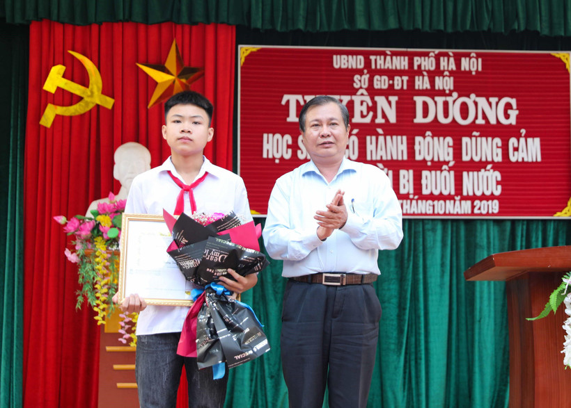 Phó Giám đốc Sở Giáo dục và Đào tạo Hà Nội Lê Ngọc Quang trao Bằng khen của Chủ tịch Ủy ban Nhân dân thành phố Hà Nội cho em Phan Trung Hiếu. (Ảnh: Thanh Tùng/TTXVN)
