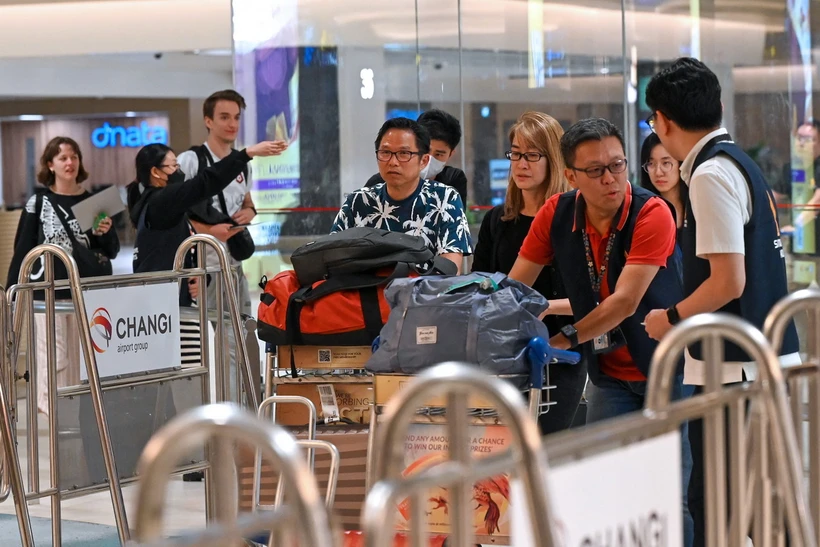 Hành khách rời máy bay của Hãng hàng không Singapore Airlines, sau khi máy bay phải hạ cánh khẩn cấp xuống Bangkok (Thái Lan) ngày 21/5 do gặp sự cố nhiễu động không khí. (Ảnh: AFP/TTXVN)