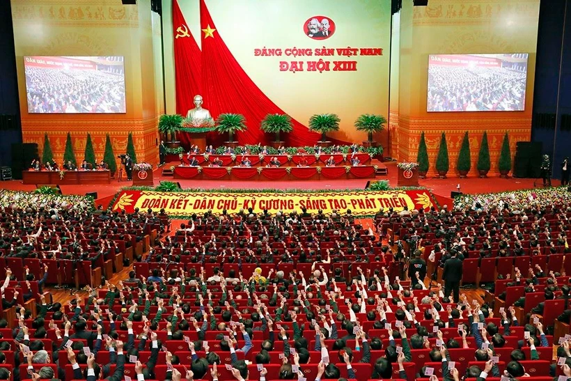 Các đại biểu biểu quyết, thông qua Nghị quyết Đại hội XIII của Đảng. (Ảnh: TTXVN)