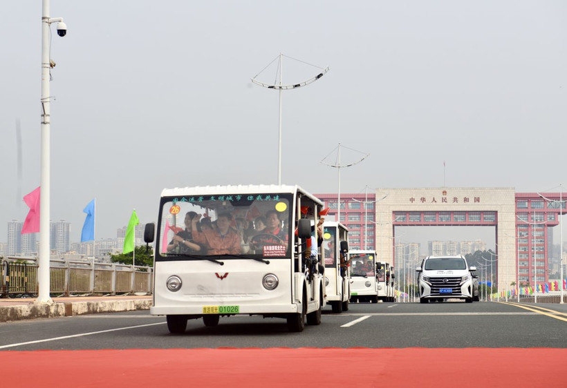 Các xe trung chuyển (xe điện) chở khách du lịch xuất cảnh đi qua vạch phân quảng cầu Bắc Luân 2. (Ảnh: Thanh Vân/TTXVN)