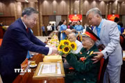 Tổng Bí thư, Chủ tịch nước Tô Lâm tặng hoa chúc mừng các đảng viên nhận Huy hiệu Đảng. (Ảnh: Thống Nhất/TTXVN)