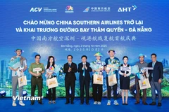 Những du khách đầu tiên từ Thâm Quyến (Trung Quốc) đến Đà Nẵng được chào đón và tặng quà lưu niệm. (Ảnh: PV/Vietnam+)