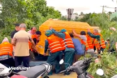 Cán bộ, chiến sỹ hỗ trợ an táng người dân bị ảnh hưởng do mưa lũ. (Ảnh: PV/Vietnam+)