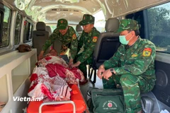Cán bộ, chiến sĩ Đồn biên phòng Ga Ry kịp thời đưa sản phụ người Lào đi cấp cứu. (Ảnh: PV/Vietnam+)
