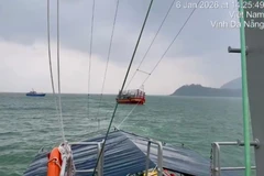 Tàu biên phòng lai dắt tàu cá gặp nạn. (Ảnh: PV/Vietnam+)