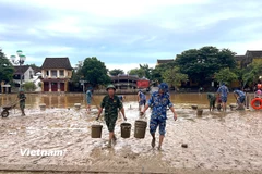 Hơn 400 cán bộ, chiến sỹ của Bộ Chỉ huy Quân sự thành phố Đà Nẵng và Sư đoàn Phòng không 375 hót dọn bùn đất phố cổ Hội An. (Ảnh: Thanh Phong/Vietnam+)