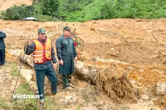 Lực lượng chức năng tiếp cận sâu và khu vực sạt lở và tìm thấy 1 thi thể. (Ảnh: PV/Vietnam+)