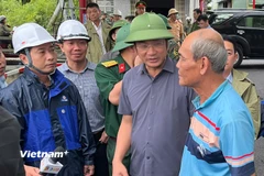 Bí thư Thành ủy Đà Nẵng Lê Ngọc Quang (Người thứ 2 từ phải qua) hỏi thăm người dân tại khu vực "rốn lũ" đường Mẹ Suốt. (Ảnh: PV/Vietnam+)