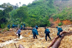 Bộ đội chi làm nhiều nhóm đi bộ vượt các điểm sạt lở, đường núi và sông suối gùi nhu yếu phẩm đến 14 hộ dân bị cô lập. (Ảnh: PV/Vietnam+)