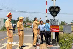 Đội Cảnh sát giao thông đường sắt số 2 thuộc Phòng 6 Cục Cảnh sát giao thông phối hợp các đơn vị lắp đặt biển tuyên truyền. (Ảnh: PV/Vietnam+)