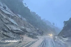 Sạt lở ta luy khiến bùn đất tràn xuống đường ở Quốc lộ 14E. (Ảnh: PV/Vietnam+)