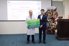 Đồng chí Hồng Quang - Thành viên Hội đồng quản trị, Chủ tịch Công đoàn Vietcombank (bên phải) trao biển tượng trưng hỗ trợ 500 triệu đồng cho Bệnh viện Đa khoa Khu vực Hóc Môn. (Ảnh: Vietnam+) 