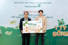 Anh Quang Nam (bên phải) nhận giải đặc biệt trị giá 1 tỷ đồng trong chương trình “Tiết kiệm hôm nay - Trúng ngay tiền tỷ” tại Vietcombank chi nhánh Tân Bình. (Ảnh: Vietnam+)