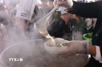 Nước phở nóng sốt được chan vào bát. (Ảnh: Trần Việt/TTXVN)