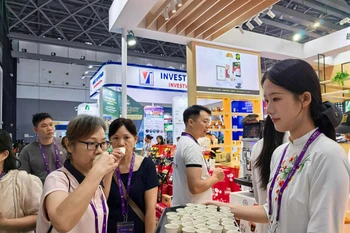 Người tiêu dùng thưởng thức càphê Việt Nam tại CAEXPO ngày 19/9. (Nguồn: chinanews)