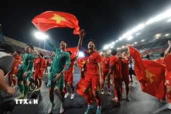 Các cầu thủ U22 Việt Nam hân hoan chia vui với người hâm mộ trên sân Rajamangala. (Ảnh: Minh Quyết/TTXVN)