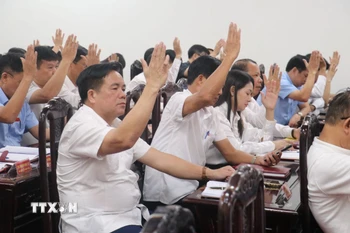 Các đại biểu biểu quyết thông qua Nghị quyết tại Kỳ họp. (Ảnh: Vũ Quang/TTXVN)