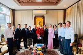 Tổng Lãnh sự Khamphay Phanthongdy trao lẵng hoa tươi thắm chúc mừng Tổng Lãnh sự Đinh Hoàng Linh, phu nhân và tập thể cán bộ nhân viên Tổng Lãnh sự quán Việt Nam. (Ảnh: PV/Vietnam+)