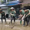 Hàng trăm cán bộ, chiến sỹ Công an tỉnh Lào Cai giúp đỡ nhân dân khắc phục hậu quả mưa lũ. (Ảnh: Đinh Thùy/TTXVN)