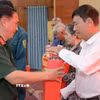 Thừa ủy quyền của Quân ủy Trung ương, Bộ Quốc phòng, Bộ Chỉ huy Quân sự tỉnh An Giang trao quà cho các gia đình chính sách, người có công với cách mạng Châu Thành. (Ảnh: Văn Sĩ/TTXVN)