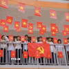 Học sinh Trường Phổ thông nội trú Tiểu học và THCS Sam Mứn tươi vui bên những lá cờ Đảng, cờ Tổ quốc được trang trí trên hành lang. (Ảnh: Xuân Tư/TTXVN)