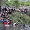 Người di cư vượt sông Rio Grande để vào Mỹ từ thành phố Matamoros, bang Tamaulipas, Mexico, ngày 11/5/2023. (Ảnh: AFP/TTXVN)
