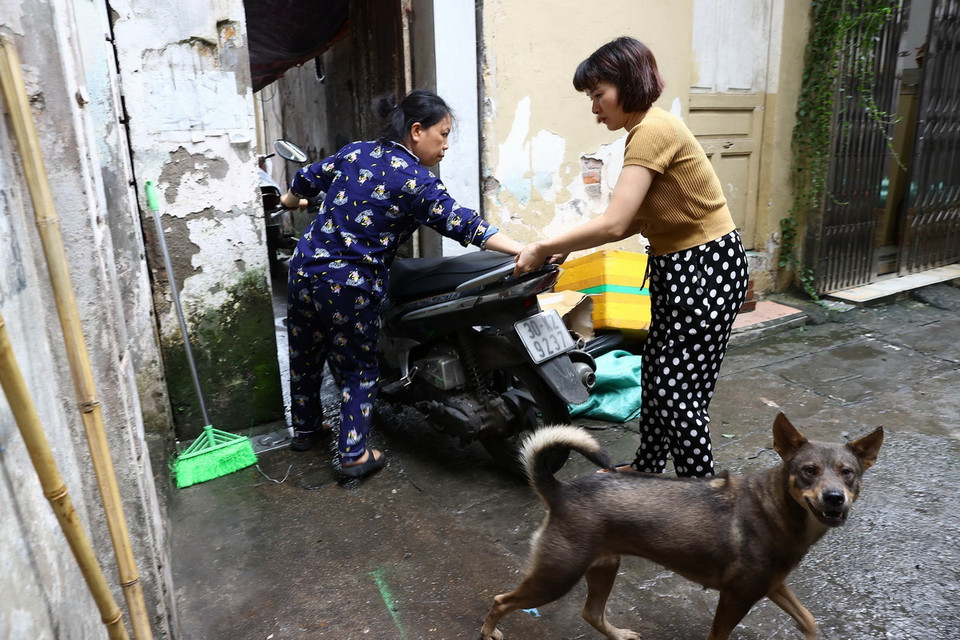 Người dân tại vùng ven bờ sông Hồng, quận Hoàn Kiếm chủ động di dời tài sản lên vùng địa hình cao, chiều 10/9. (Ảnh: Huy Hùng/TTXVN)
