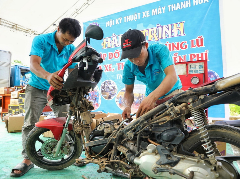 Những người thợ sửa xe máy của Hội kỹ thuật xe máy Thanh Hóa sửa xe cho người dân tại địa điểm Nhà văn hóa tổ 13, phường Yên Ninh trong sáng ngày 18/9. (Ảnh: Tuấn Anh/TTXVN)