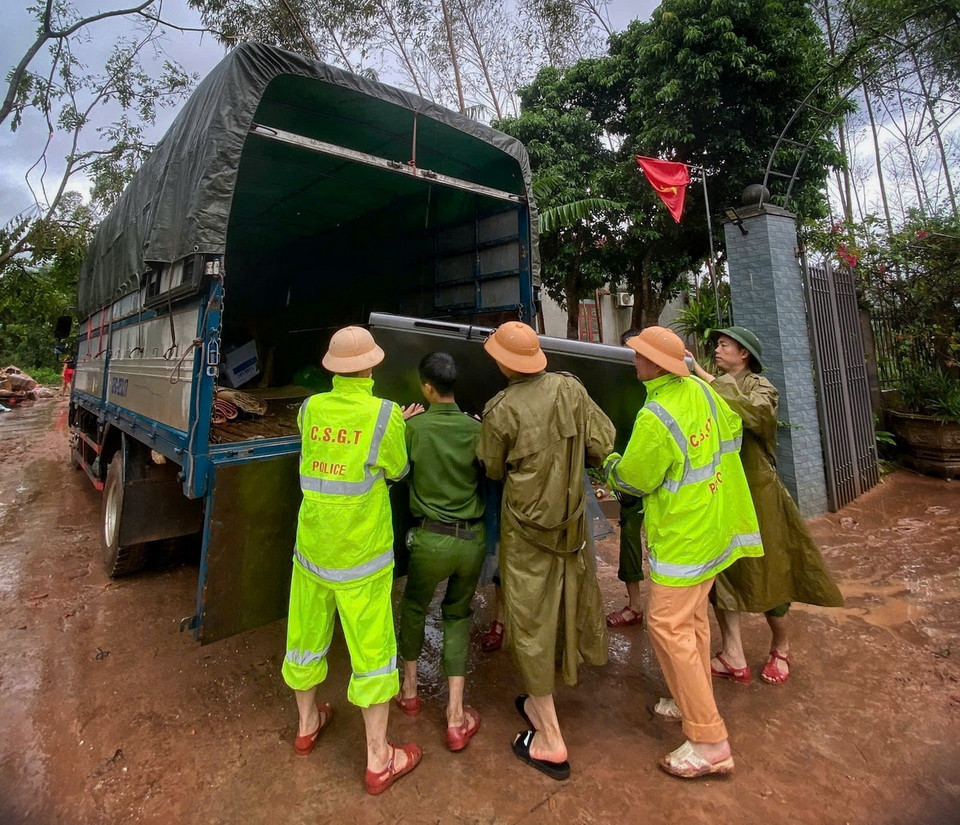 Cán bộ chiến sỹ Công an huyện Sơn Động giúp dân vận chuyển đồ đạc sau khi lũ rút. (Ảnh: TTXVN phát)
