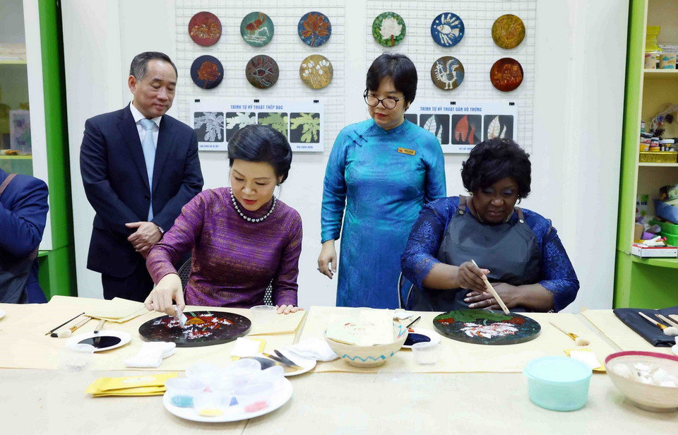 Phu nhân Tổng Bí thư, Chủ tịch nước Tô Lâm, bà Ngô Phương Ly và Phu nhân Tổng thống Mozambique Filipe Jacinto Nyusi, bà Isaura Ferrao Nyusi trải nghiệm sáng tác tranh sơn mài tại Bảo tàng Mỹ thuật Việt Nam. (Ảnh: Phạm Kiên/TTXVN)