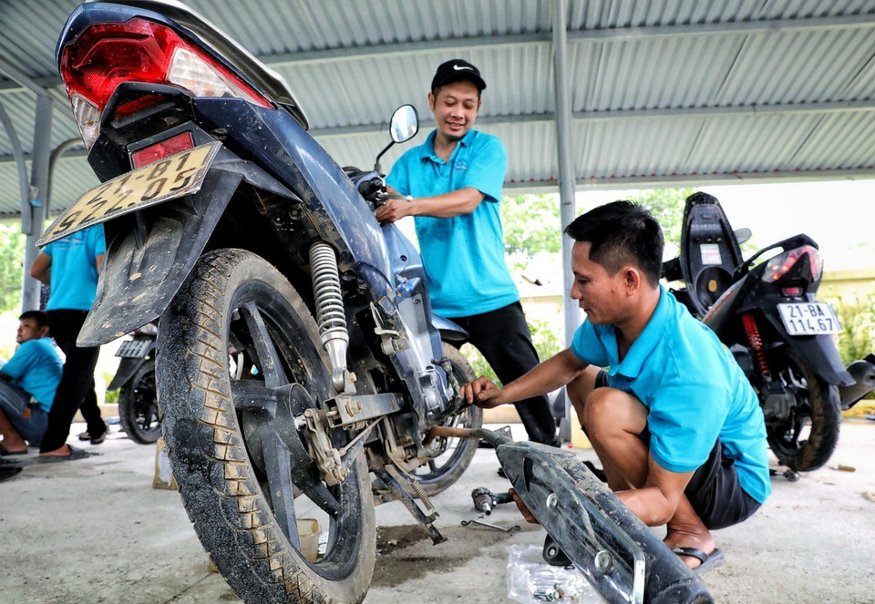 Những người thợ sửa xe máy của Hội kỹ thuật xe máy Thanh Hóa sửa xe cho người dân tại địa điểm Nhà văn hóa tổ 13, phường Yên Ninh trong sáng 18/9. (Ảnh: Tuấn Anh/TTXVN)