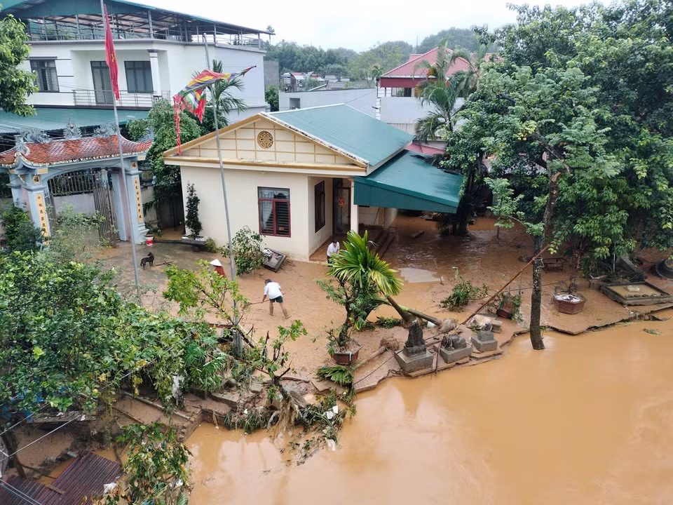 Người dân ở tổ 4, phường Minh Tân, tranh thủ dọn dẹp khi nước rút. (Ảnh: Tuấn Anh/TTXVN)