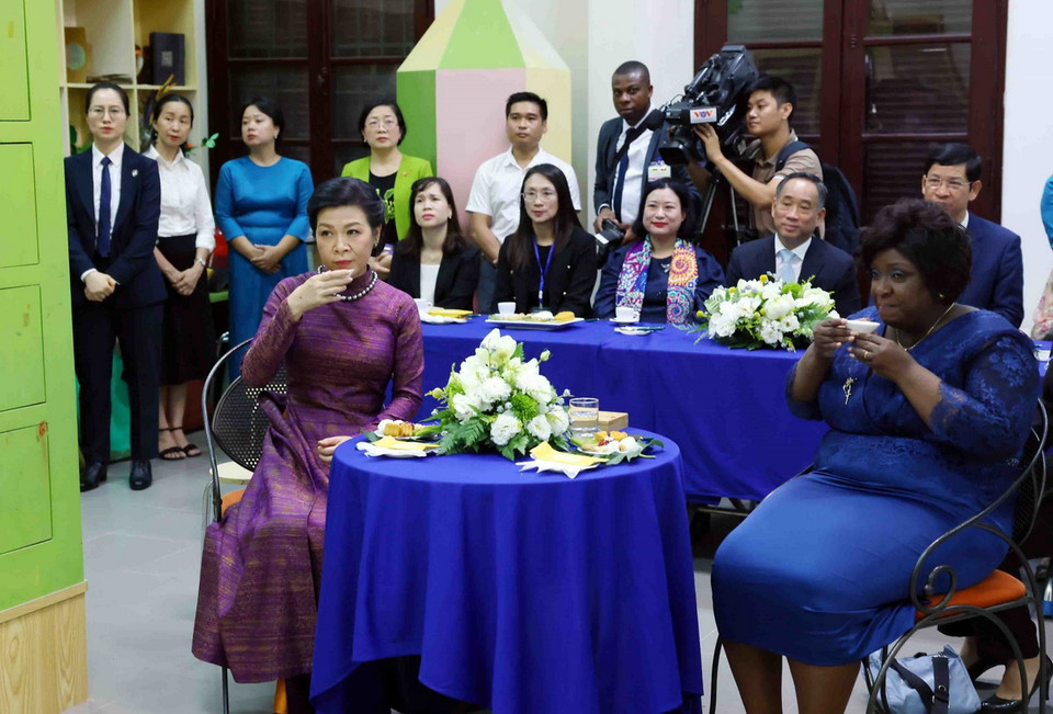 Phu nhân Tổng Bí thư, Chủ tịch nước Tô Lâm, bà Ngô Phương Ly và Phu nhân Tổng thống Mozambique Filipe Jacinto Nyusi, bà Isaura Ferrao Nyusi cùng thưởng thức trà và bánh Trung thu trong khi xem giới thiệu quá trình sáng tác tranh sơn mài. (Ảnh: Phạm Kiên/TTXVN)