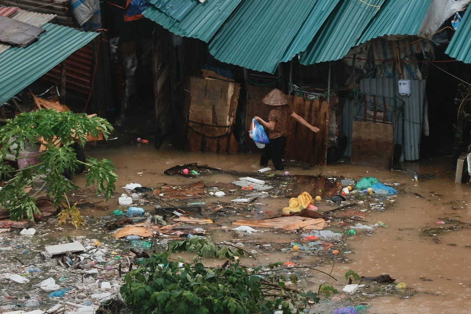 Người dân quanh khu vực bờ sông chuyển đồ khi nước ngập. (Ảnh: Minh Quyết/TTXVN)