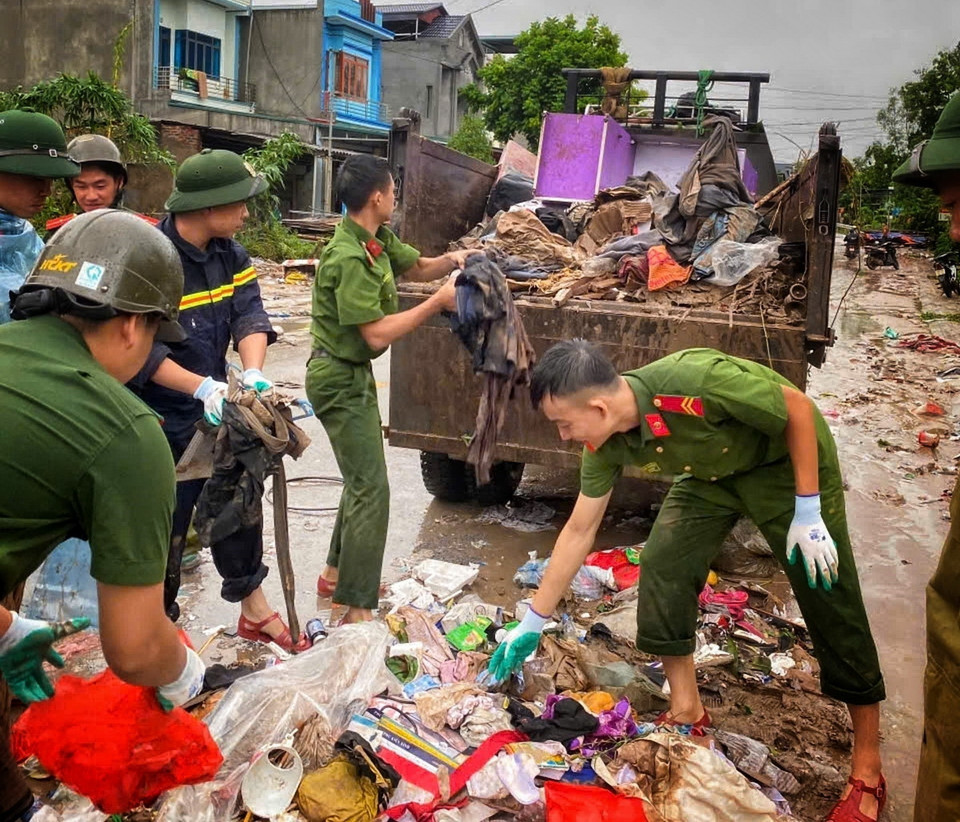 Cán bộ chiến sỹ Công an huyện Sơn Động giúp dân dọn dẹp môi trường sau khi lũ rút. (Ảnh: TTXVN phát)