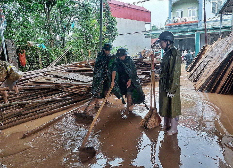 Cán bộ, chiến sỹ Ban Chỉ huy quân sự huyện Sơn Động giúp dân dọn dẹp môi trường sau khi lũ rút. (Ảnh: TTXVN phát)