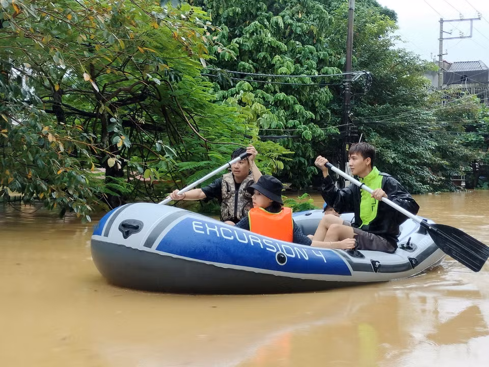 Lực lượng cứu hộ đưa người dân ra khỏi khu vực ngập úng. (Ảnh: Tuấn Anh/TTXVN)